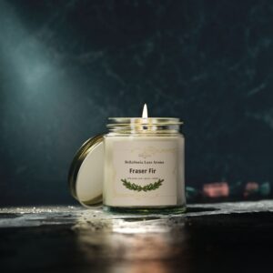 Fraser Fir scented candle in an amber glass jar with a gold lid, styled with pine needles and a cozy winter setting