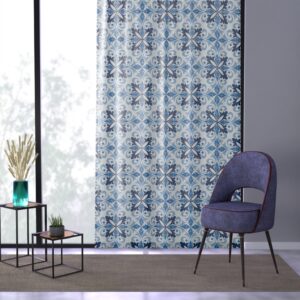 Sheer curtain with blue tile pattern hanging on a window